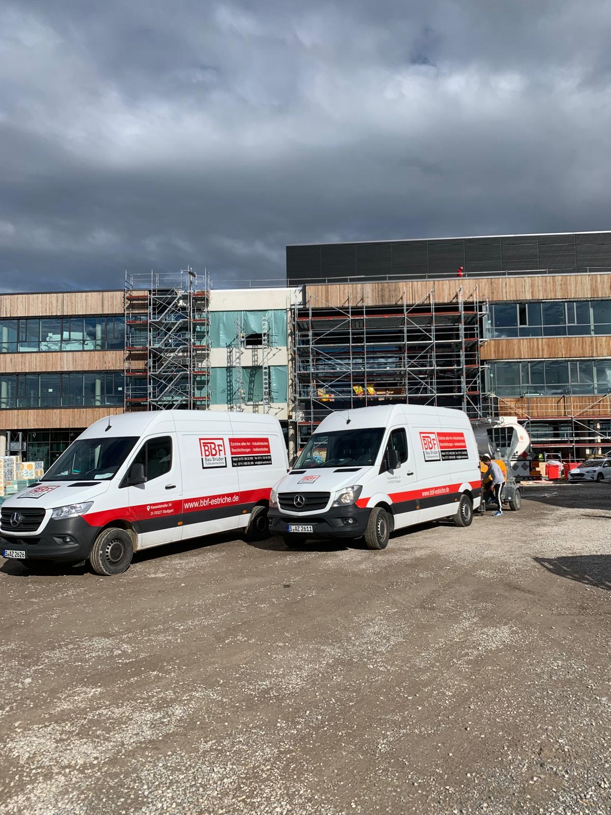 Zwei BBF-Firmenfahrzeuge vor einem Neubau mit Gerüst